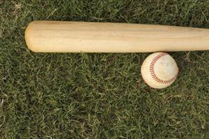 an image of a baseball bat and a ball on the grass.