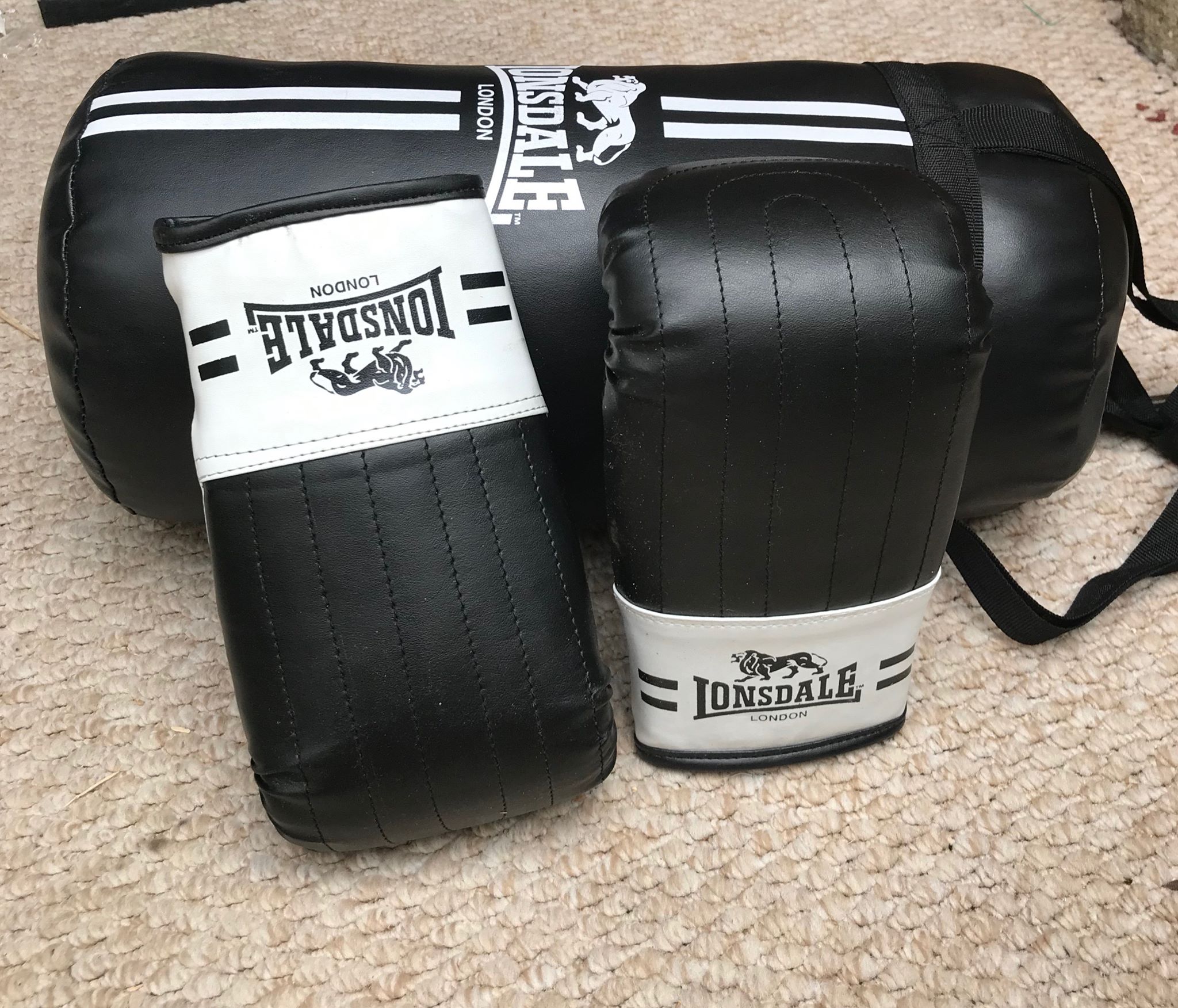 A set of black boxing gloves on the floor.